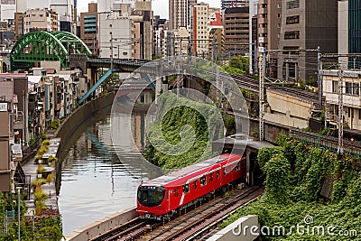 TOKYO, JAPAN - AUGUST 09 2023: Trains passing a busy intersection and tunnel over the Kanda River at the Hijiribashi Bridge, Tokyo Editorial Stock Photo