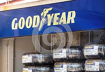 A Good Year stand outside of a gas station with brand new car wheels Editorial Stock Photo