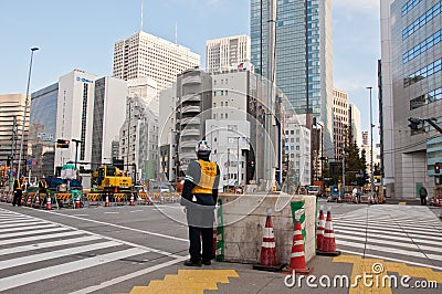 TOKYO, JAPAN - DECEMBER 1, 2018: Japanese construction workers stand to wait for traffic light before crossing the road near Editorial Stock Photo