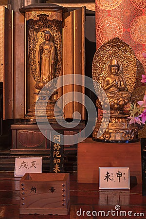 Wooden statue representing Buddha Amida Nyorai and Dainichi Nyorai in the Tennoji temple of Tendai Buddhism in the Yanaka cemetery Editorial Stock Photo