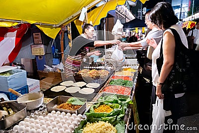 Tokyo, Japan - August 15, 2020 : senior japanese people are buying japanese fried noodle yakisoba from the food stall at street Editorial Stock Photo