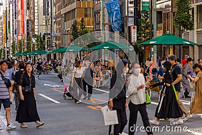 TOKYO, JAPAN - JULY 30 2023: Shoppers on the closed roads of Ginza, the luxury retail district of central Tokyo Editorial Stock Photo