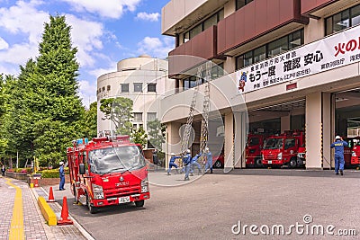 Japanese red fire trucks with firefighters rescuers practicing to deploy the ladders. Editorial Stock Photo