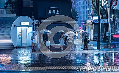 Tokyo, Japan - June 10, 2018: People in the rain standing at the crosswalk. Editorial Stock Photo