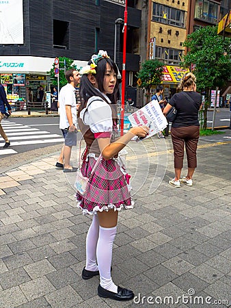 TOKYO, JAPAN JUNE 28 - 2017: Unidentified woman holsing in her hands and informative fliers at famous Kabukicho red Editorial Stock Photo