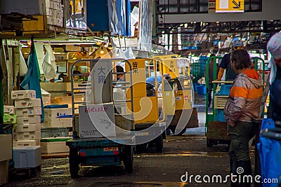 TOKYO, JAPAN JUNE 28 - 2017: Unidentified workers with a small cargo yellow machine, inside of a Fish Market Tsukiji in Editorial Stock Photo