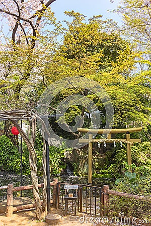 Pergola and Japanese gold foil torii gate in the pond of Atago shrine. Stock Photo