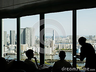 Tokyo, Japan - Silhouette of customers and waitress at executive lounge of Conrad Tokyo. Editorial Stock Photo