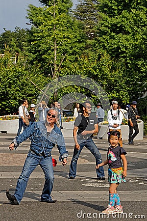 A little girl joins the dancers for fun on Yoyogi Park Editorial Stock Photo