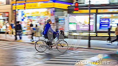 Night panning photography of unidentified man riding bicycle at Shibuya Square.The one of the wor Editorial Stock Photo