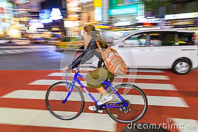 Night panning photography of unidentified woman riding bicycle at Shibuya Square.The one of the w Editorial Stock Photo