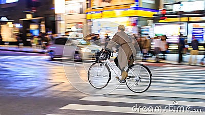 Night panning photography of unidentified woman riding bicycle at Shibuya Square.The one of the w Editorial Stock Photo