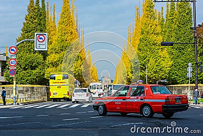 TOKYO,JAPAN-OCTOBER 25,2016:Tokyo rich yellow ginkgo tree along both side of Jingu gaien avanue in autumn with cars Famous Editorial Stock Photo