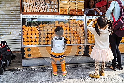 Unidentified children choosing snack at Nakamise Dori the shopping area of Sensoji temple the fam Editorial Stock Photo
