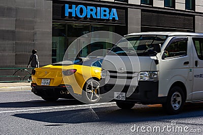 Tokyo, Japan, 26 October 2023: Yellow Sports Car and Delivery Truck on Tokyo Street Editorial Stock Photo