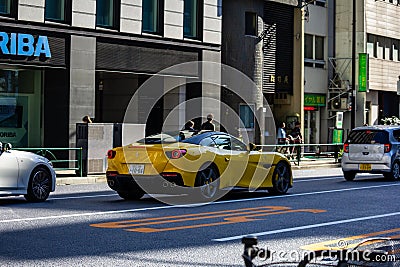 Tokyo, Japan, 26 October 2023: Yellow Sports Car Driving Past Horiba Office Building Editorial Stock Photo