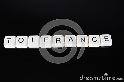 Tolerance text word title caption label cover backdrop background. Alphabet letter toy blocks on black reflective background. Whit Stock Photo