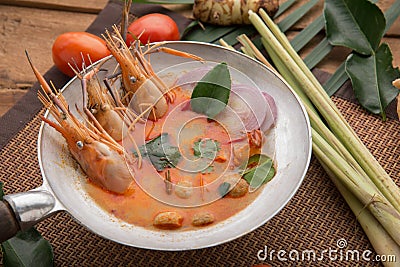 Tom yam kong or Tom yum, Tom yam is a spicy clear soup typical in Thailand Cuisine. Tom yam kong on wooden table. Thai food Editorial Stock Photo
