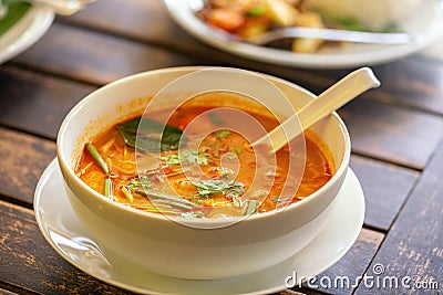 Tom Yam Kung, Thai cuisine. on a wooden table. Background - other Thai dishes Stock Photo