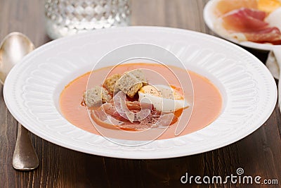 Tomato cold soup with egg and jamon on white dish Stock Photo