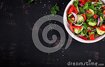 Tomato and cucumber salad with red onion, paprika, black pepper and parsley. Vegan food. Diet menu. Top view. Flat lay Stock Photo