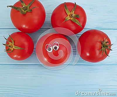 Tomato funny eyes cartoon on blue wooden positive emotion Stock Photo