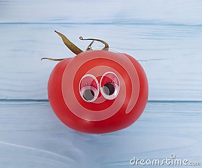 Tomato funny organic cute person eyes cartoon on blue wooden positive emotion Stock Photo