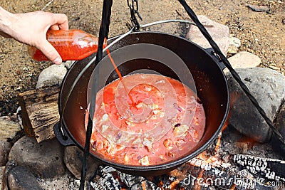 Tomato juice and meat in caldron Stock Photo