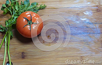 Tomato and leaves of parsley and fennel on a wooden board, flat lay Stock Photo