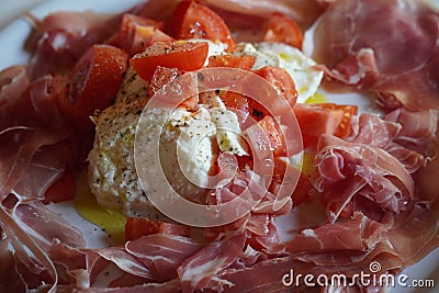 Tomato, mozzarella and Serano ham on a plate Stock Photo