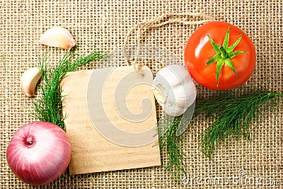Tomato, onion and garlic with cardboard price tag on sacking background Stock Photo