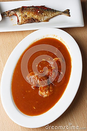 Tomato and prawn curry with fried mackerel Stock Photo