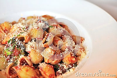 Tomato seashell pasta with shredded cheese Stock Photo