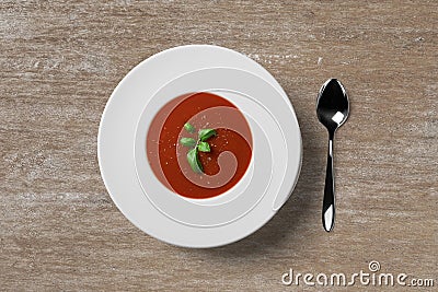 Tomato soup in white plate with green herb on the top Stock Photo