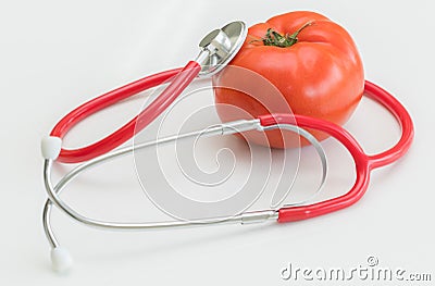 Tomato and stethoscope. Healthy food concept. Stock Photo