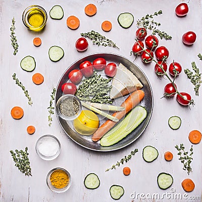 Tomatoes on a branch of thyme herb seasoning lemon cucumbers and tomatoes carrots in a pan with vegetables laid out around on wood Stock Photo