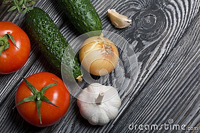 Tomatoes with green ponytails, onion, lemon and garlic head. Two green prickly cucumbers with yellow flowers. A glass with Stock Photo