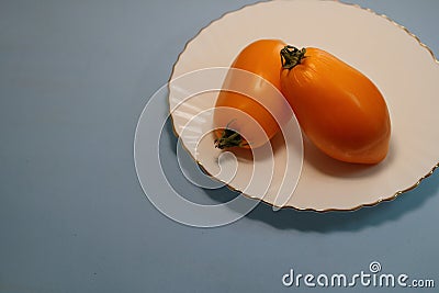 Tomatoes in a plate on a gray background. Stock Photo