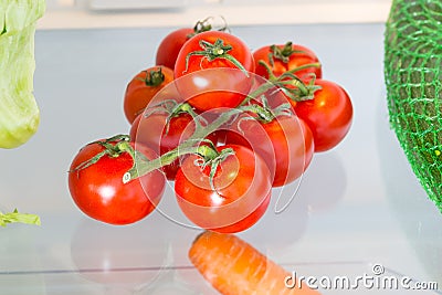 Tomatoes in the refrigerator with the door open Stock Photo