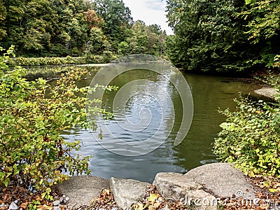 Tomlinson Run State Park in the fall in West Virginia with the fall colors and trees reflecting in the lake, the blue cloud filled Stock Photo