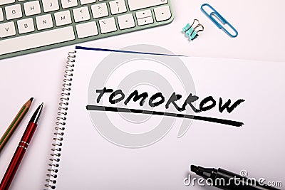 TOMORROW. Text on a notepad. office supplies on the table Stock Photo