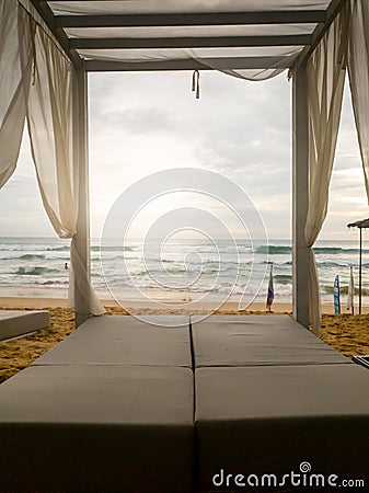 Toned image of sunbed under canopy at luxurious beach resort at ocean Stock Photo