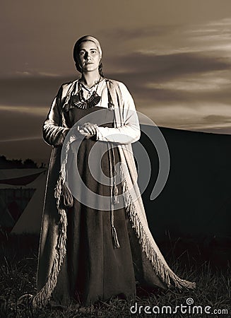 Toned vertical portrait in full length of a young woman in historical costume Stock Photo