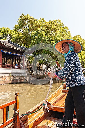 Woman captain on canal boat and pagoda, Tongli, China Editorial Stock Photo