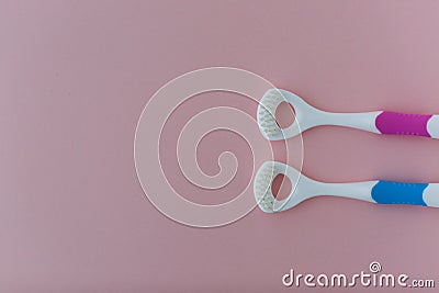 Tongue brushes on the pink background Stock Photo