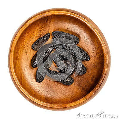 Tonka beans, also tonkin beans or tonquin beans, in a wooden bowl Stock Photo