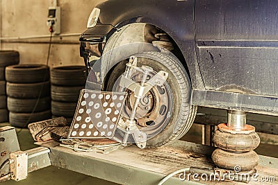 Tool fitted to the wheel of a car for steering alignment in a workshop Stock Photo