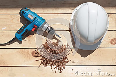 Tools for the construction of a wooden floor or terrace. Screwdriver, self-tapping screws and helmet on the wooden floor Stock Photo