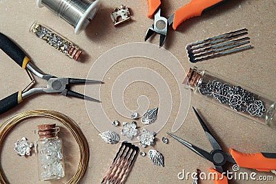 Tools for creating jewelry. Beads, crystals, glass bottles with cork lids, hair combs. Wire, cutters, pliers. Top view Stock Photo