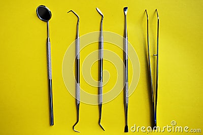 Tools for dental treatment on a yellow background Stock Photo